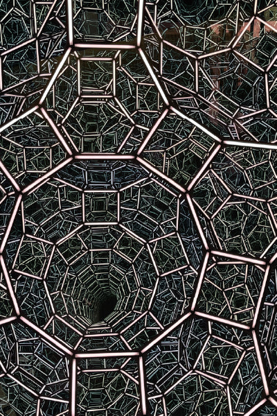 A visually intricate geometric structure composed of interconnected metal polygons, primarily pentagons and hexagons, forming a tunnel-like illusion. The pattern repeats inward, creating a sense of depth and infinity, with glowing edges that highlight the complex, symmetrical design. The overall effect is both futuristic and mesmerizing.